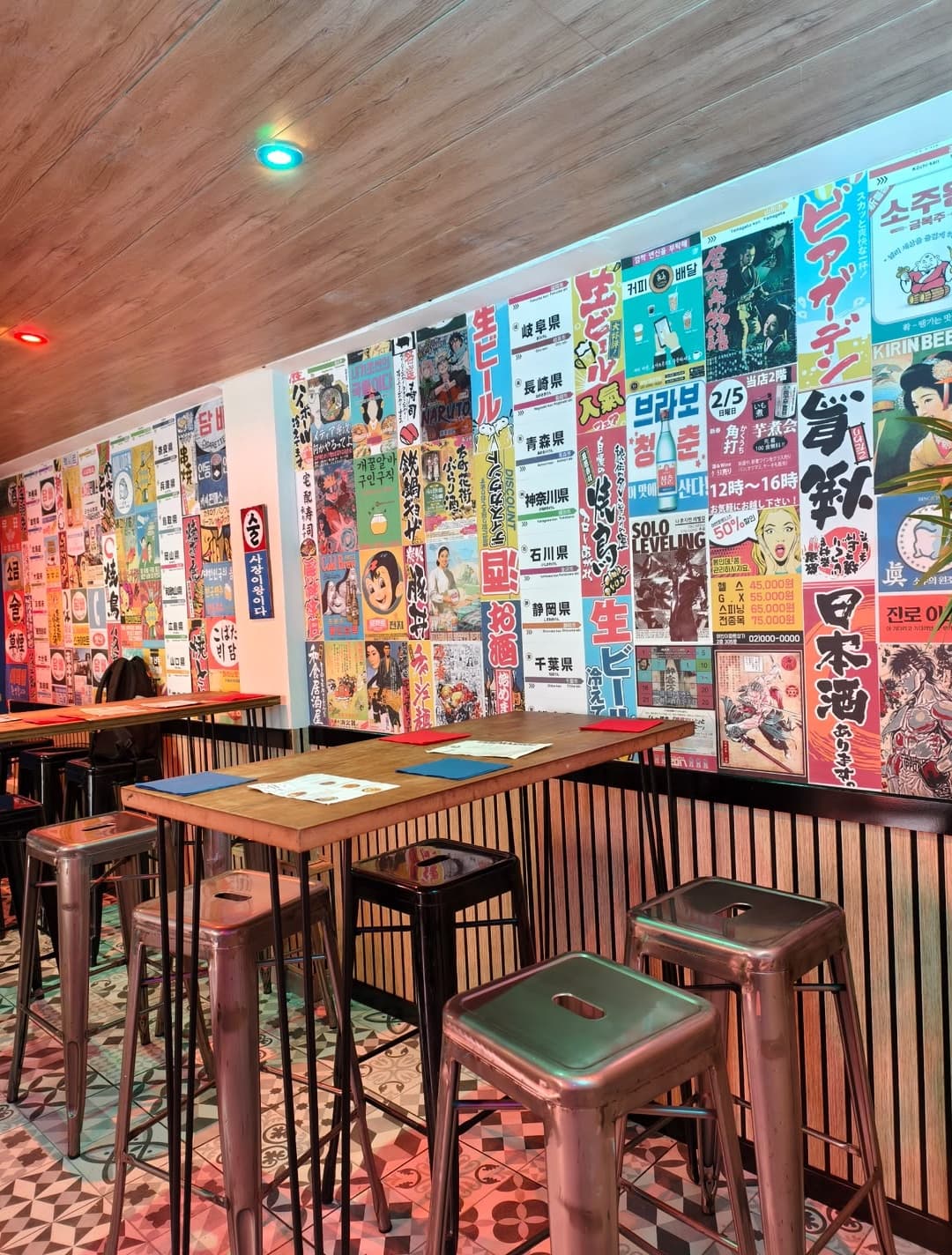 Étage supérieur avec mur de posters et tables hautes
